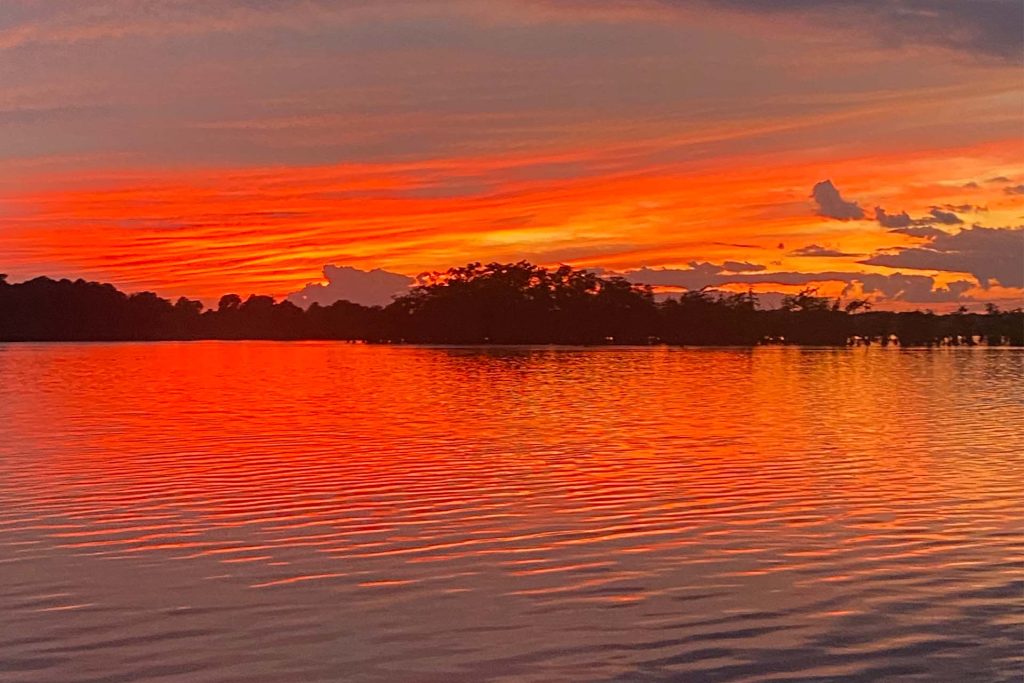 a vibrant orange sunset over the lake